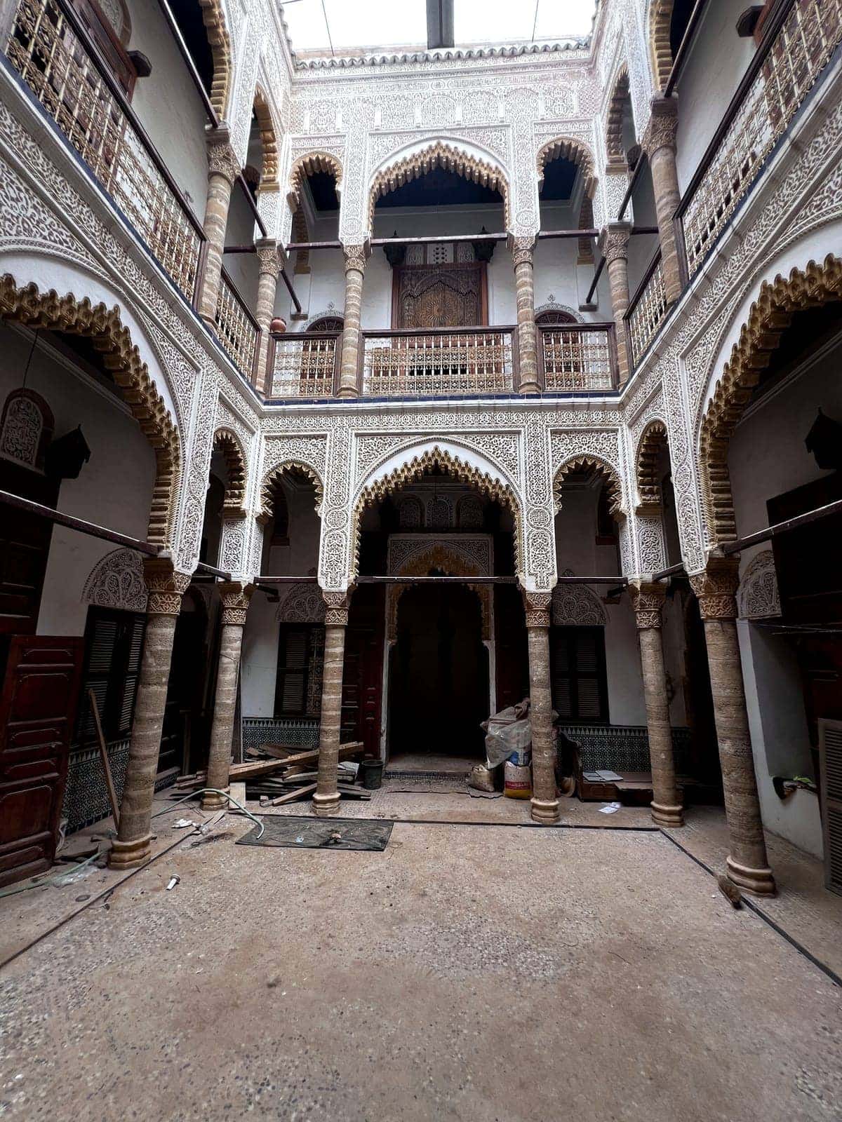 Courtyard of a riad in the Rabat medina with galleries, stone columns and carved plaster arches