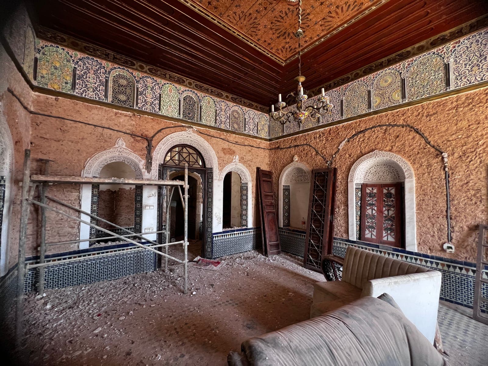 Salon de riad décapé jusqu’à la pierre, lambris de zellige et plafond en cèdre conservés