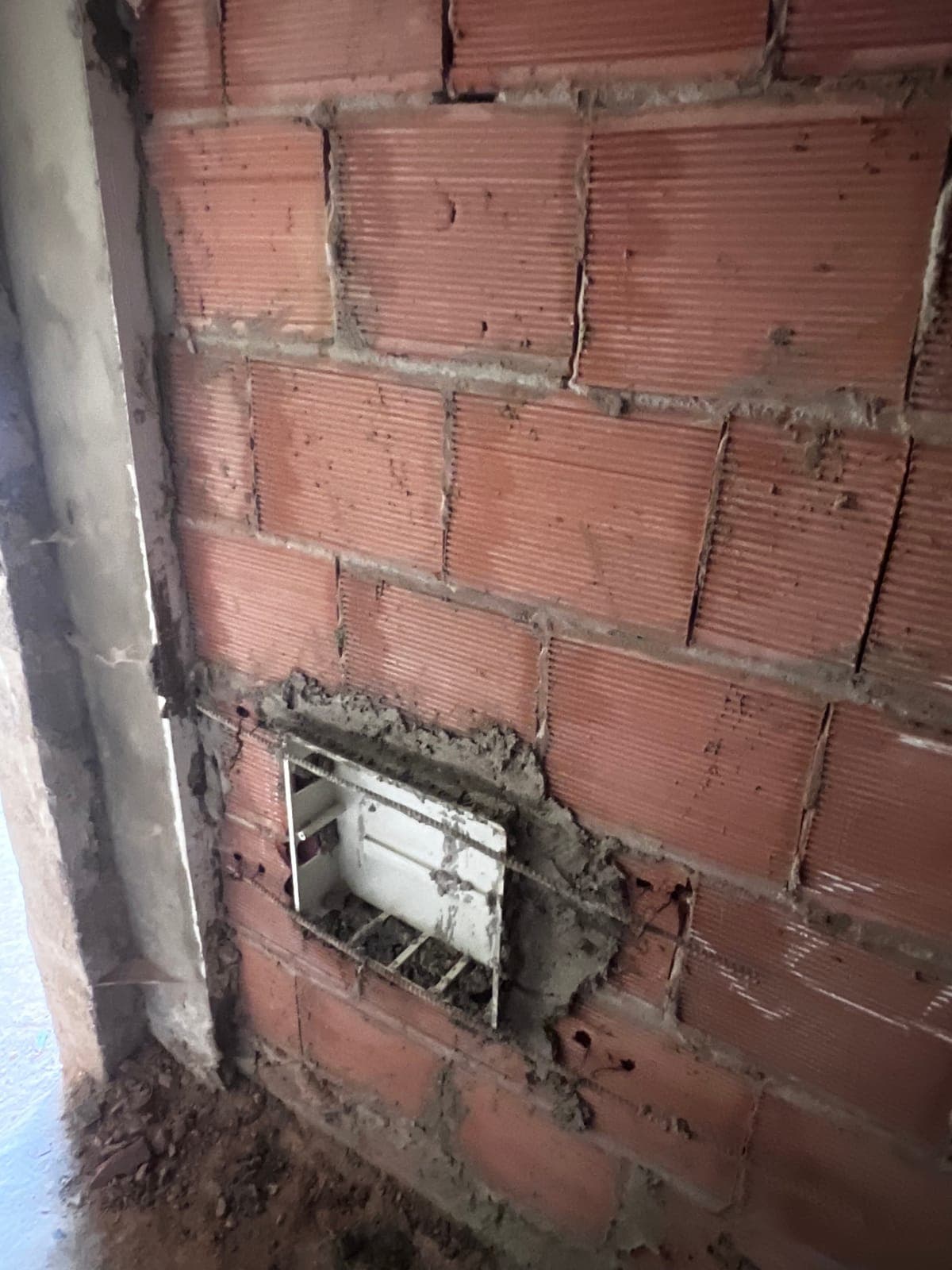 Load-bearing cross wall rebuilt in fired-clay brick with a recessed electrical box