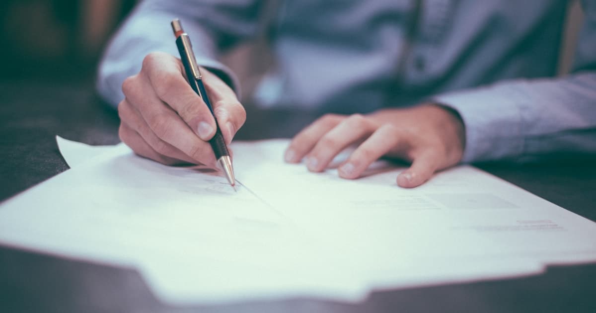 Document contractuel et stylo sur un bureau, signature de devis de construction